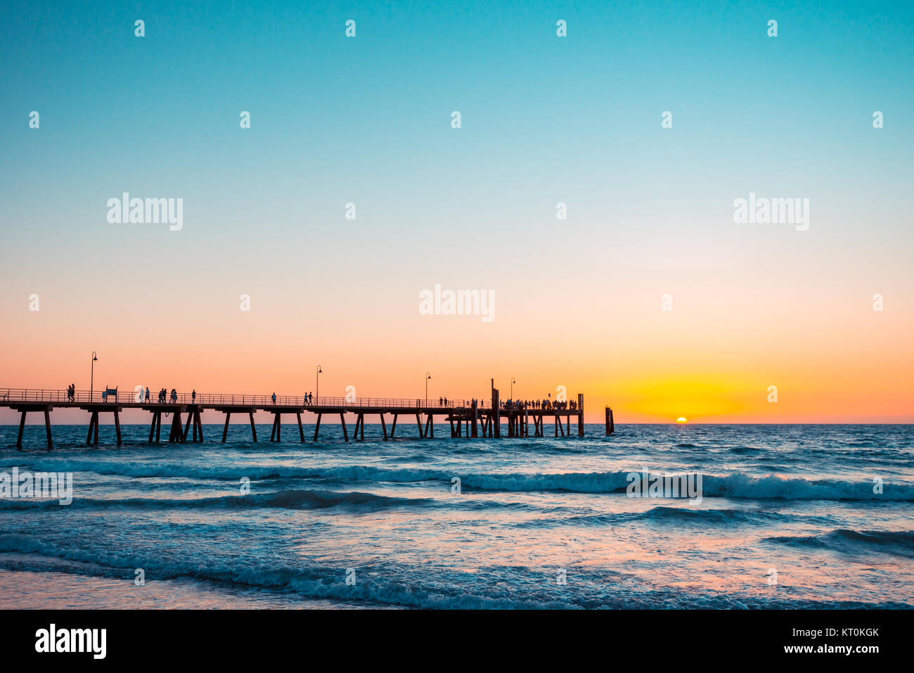 Beautiful warm sunset with people on the jetty at Glenelg beach, South Australia Stock Photo