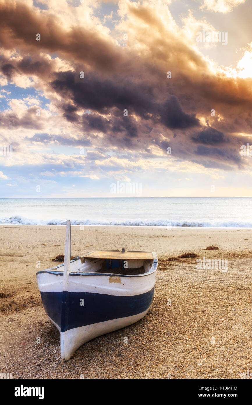 Boat on the beach at sunset time Stock Photo - Alamy
