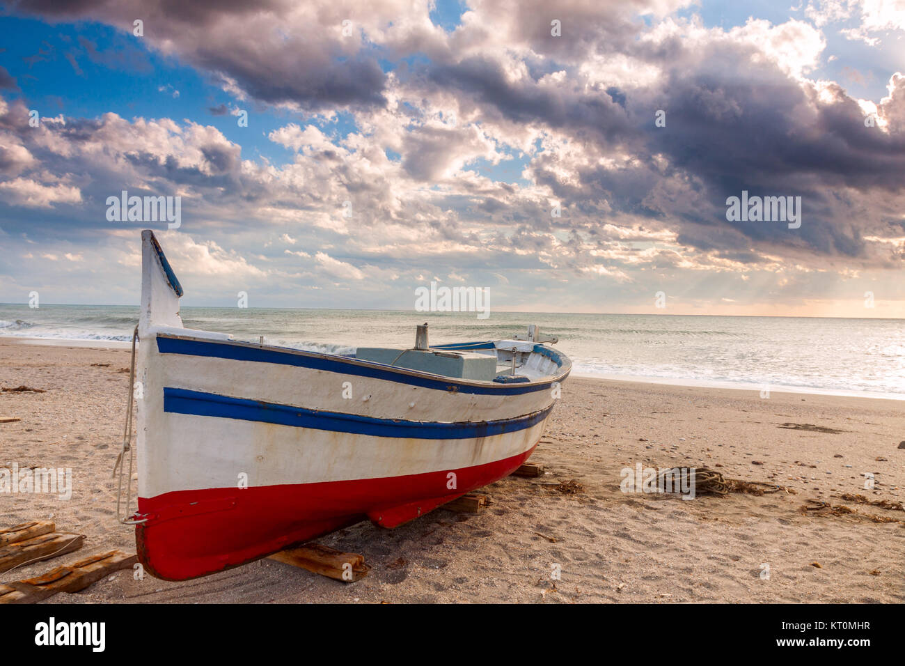 Boat on the beach at sunset time Stock Photo - Alamy