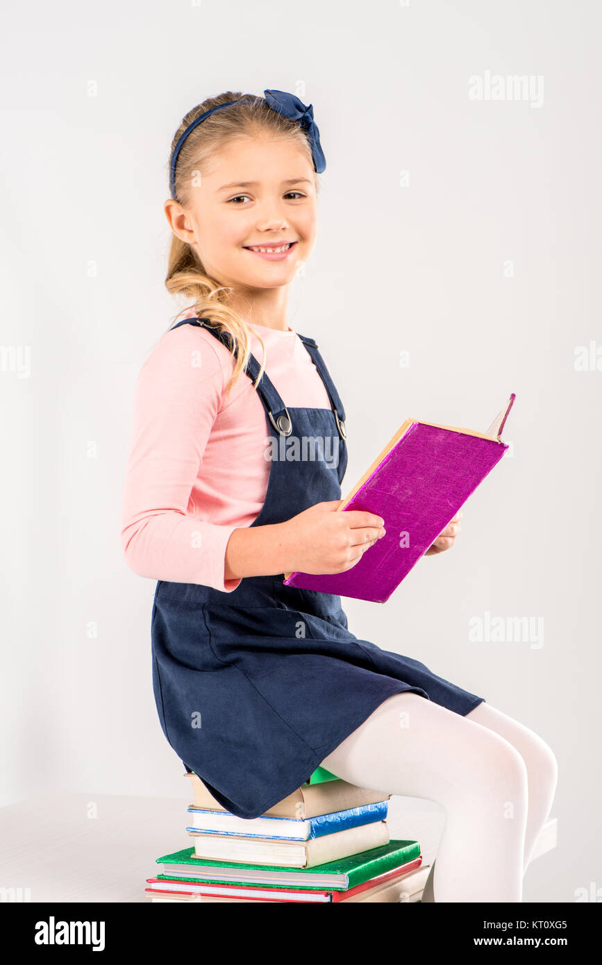 Smiling schoolgirl holding book Stock Photo - Alamy