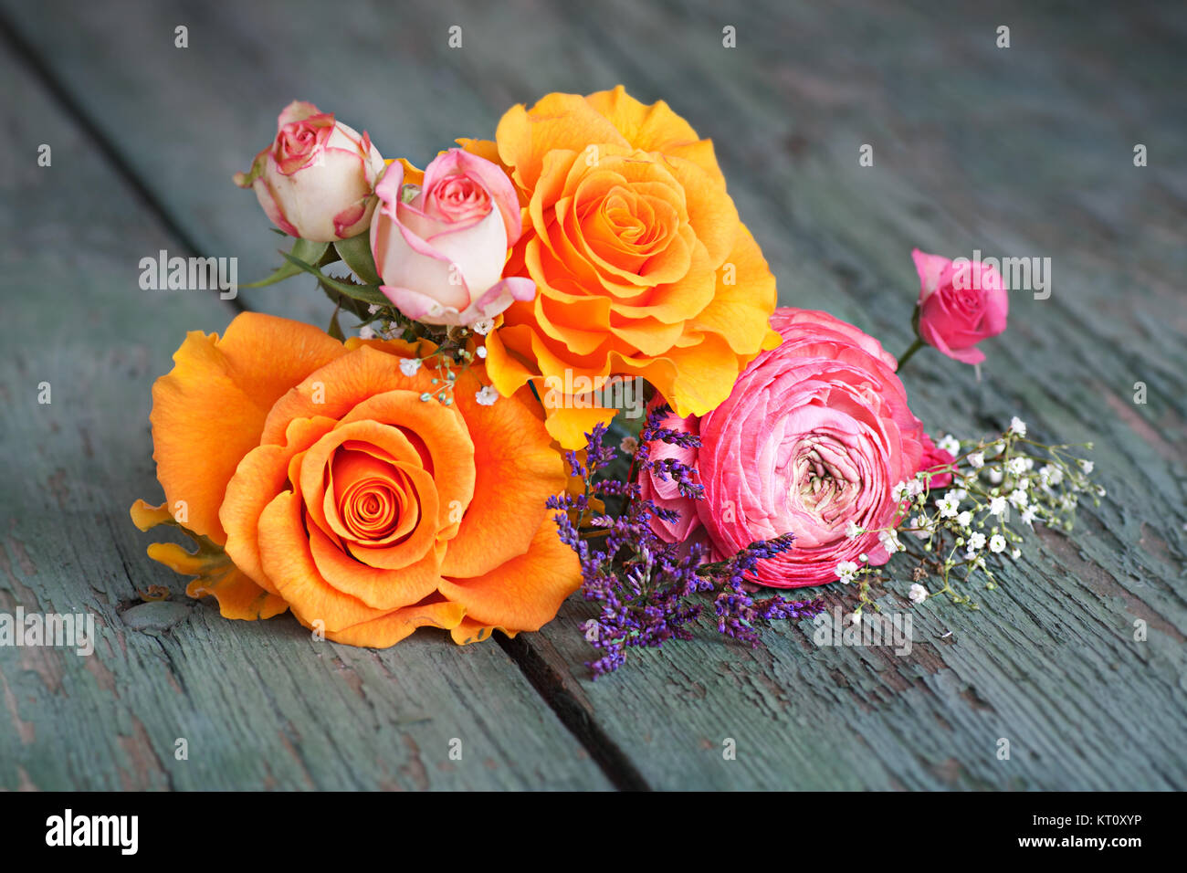 colorful-flower-decoration-with-roses-on-an-old-rustic-wooden-table