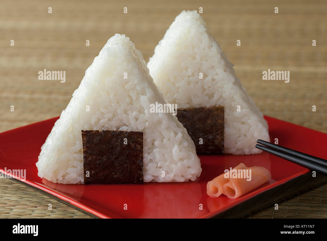 Fresh made Japanese triangular onigiri on seaweed on a dish Stock Photo