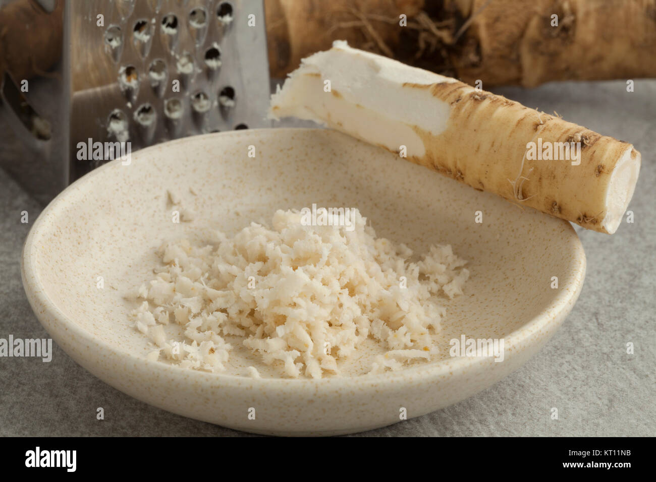 Bowl with fresh peeled and grated young horseradish close up Stock