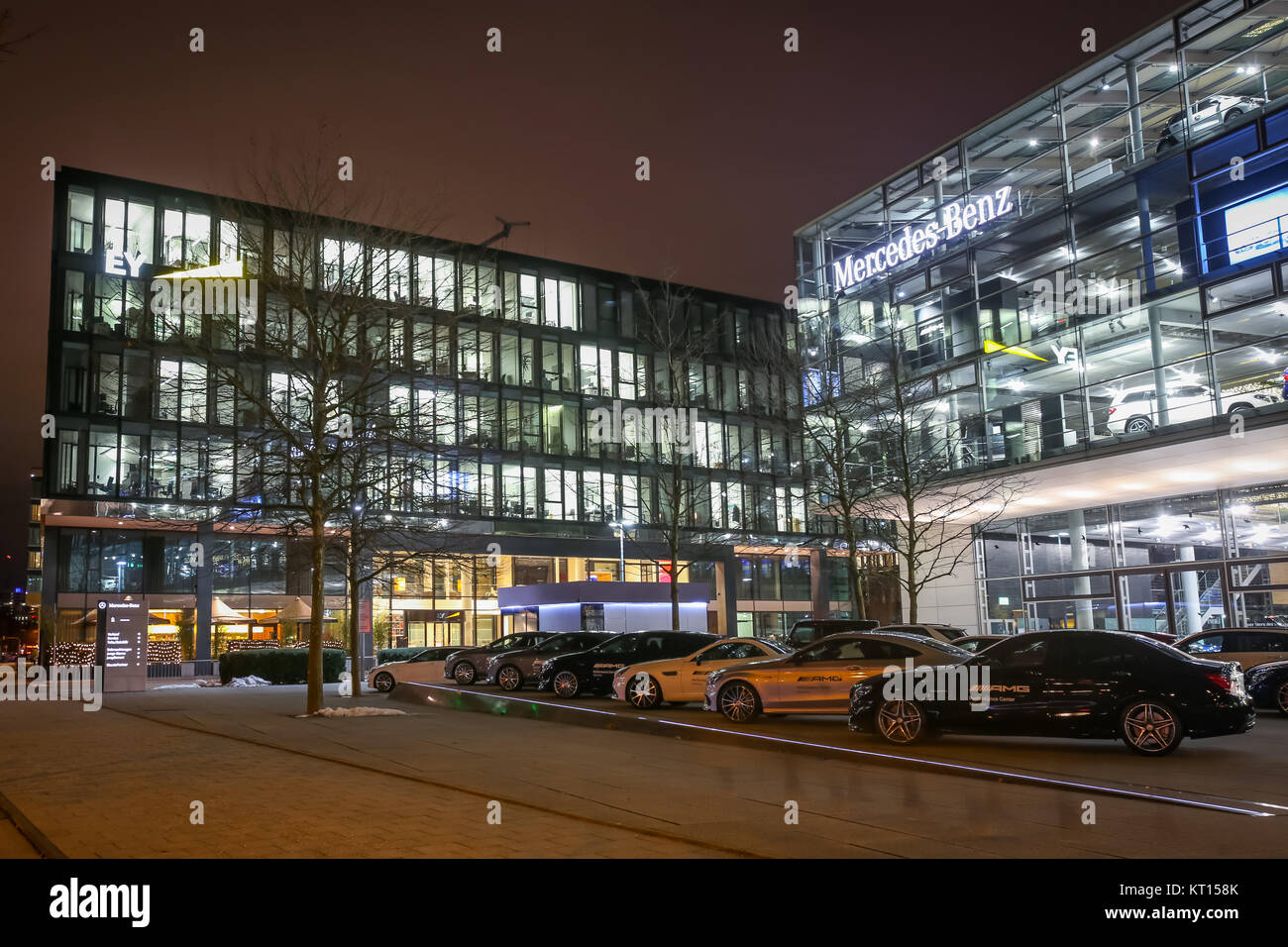 MUNICH, GERMANY - DECEMBER 11, 2017 : Exhibited cars parked in front of the Mercedes Benz dealership building at night in Munich, Germany. Stock Photo