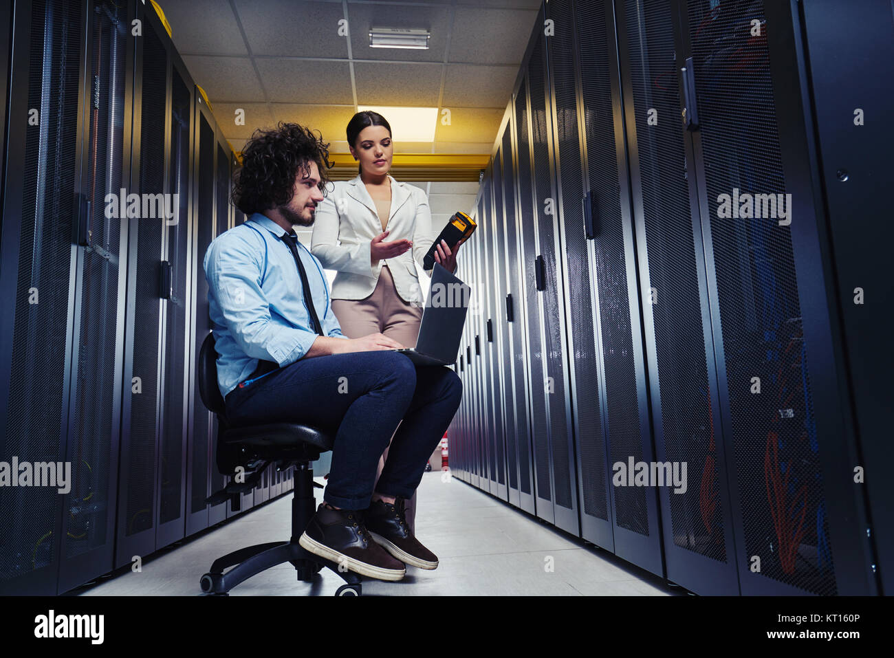 two young technicians working at a data center on server maintenance ...