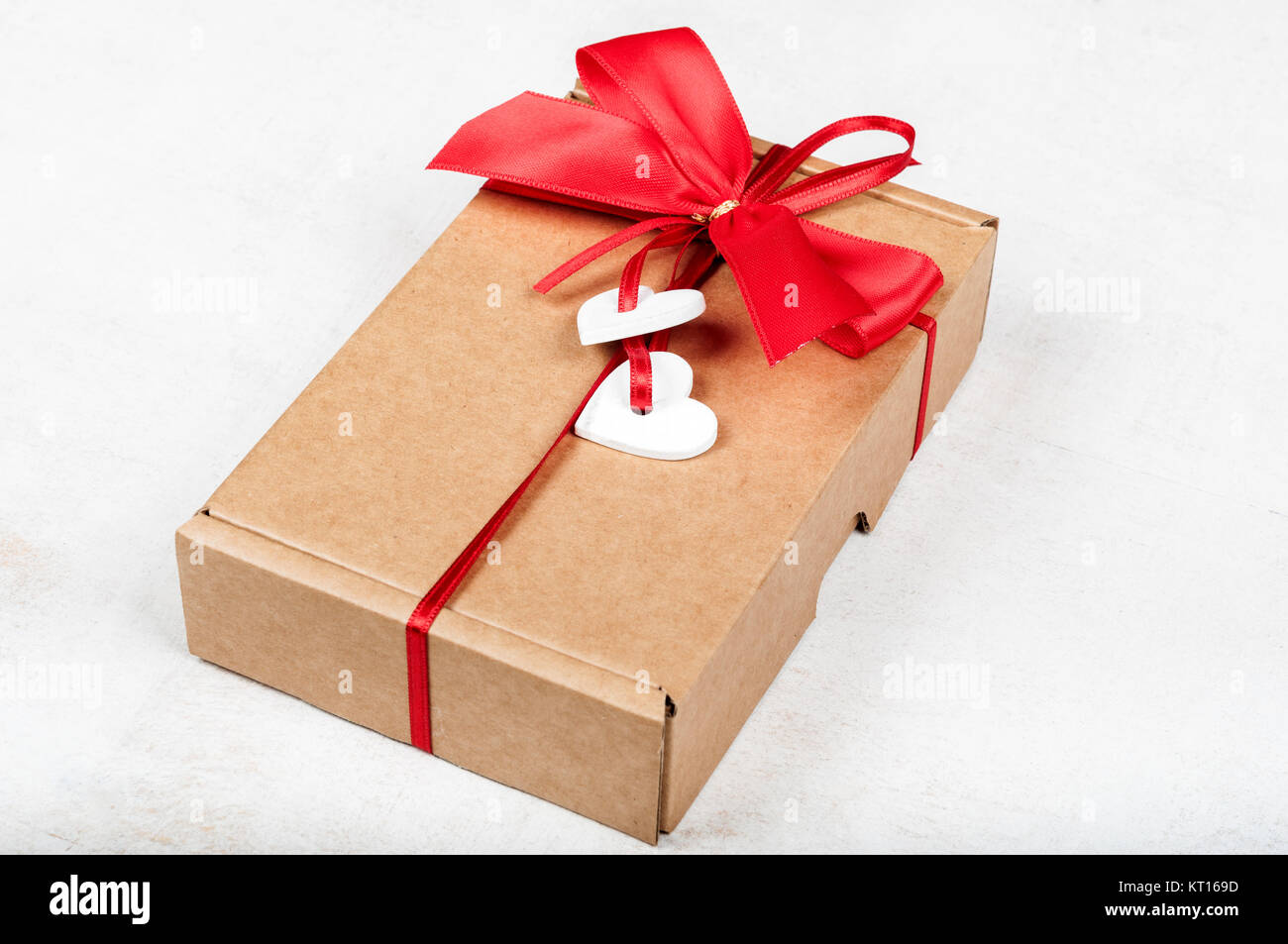 Paper gift box with red bow and white wooden hearts for Valentine's day ...