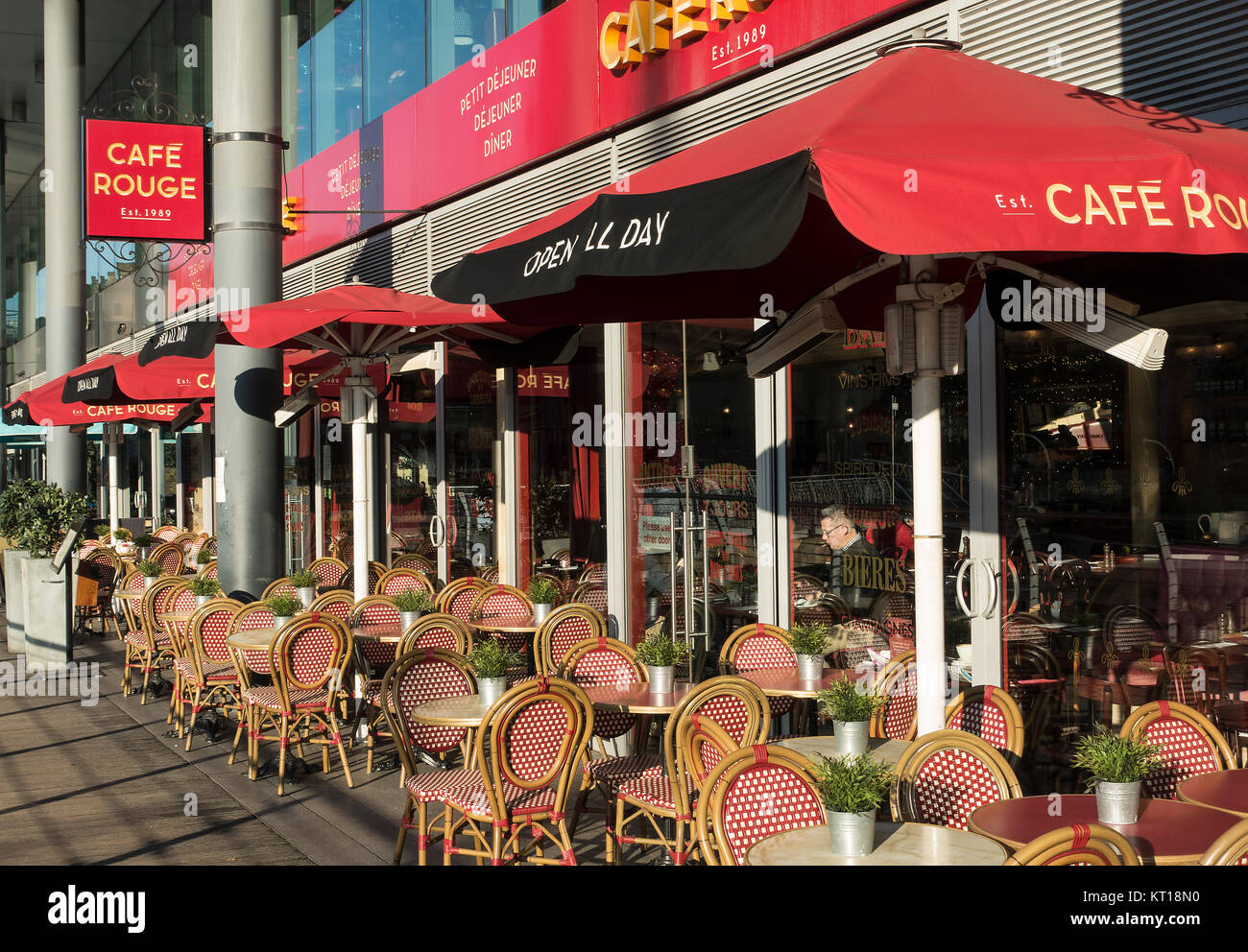External View of Café Rouge Restaurant with Red Umbrellas and Outside Tables on a Sunny Day at St Katharine Dock London England United Kingdom UK Stock Photo