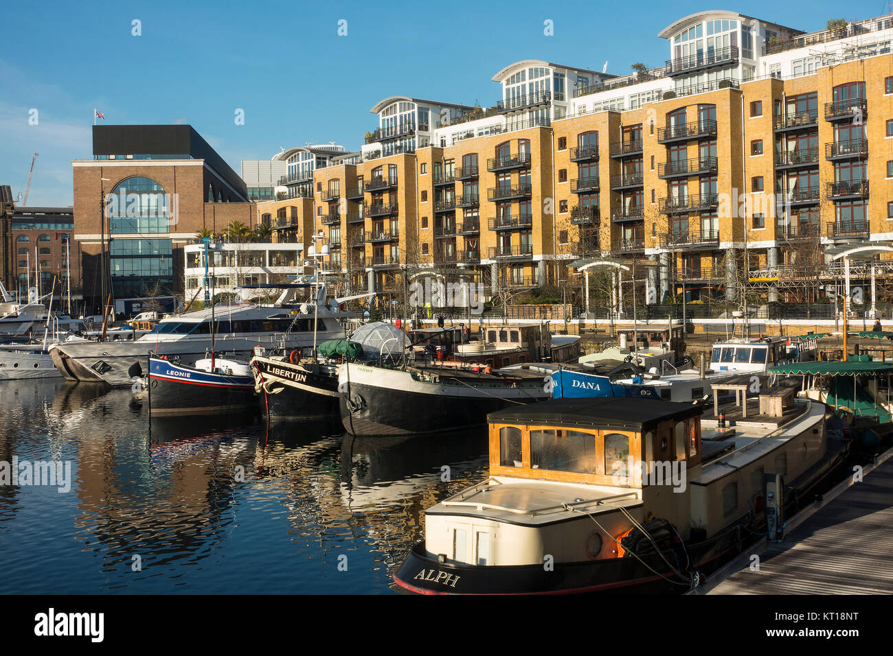 Luxury Boats Moored and Docked in the Safety of St Katharine Dock with Reflections on Water Tower Hamlets London England United Kingdom UK Stock Photo