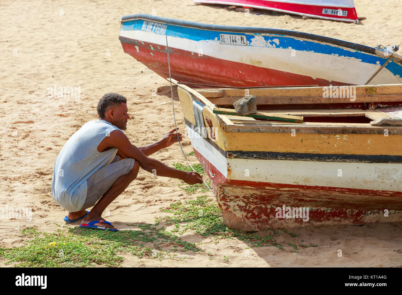 Local fisherman repairing his fishing boat on the sands at Santa Maria, Sal, Salina, Cape Verde, Africa Stock Photo