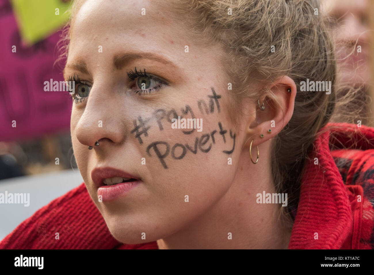 A healthcare student protesting at the Dept of Heath over axing of NHS healthcare bursaries as the hashtag #PayNotPovery on her cheek. Stock Photo