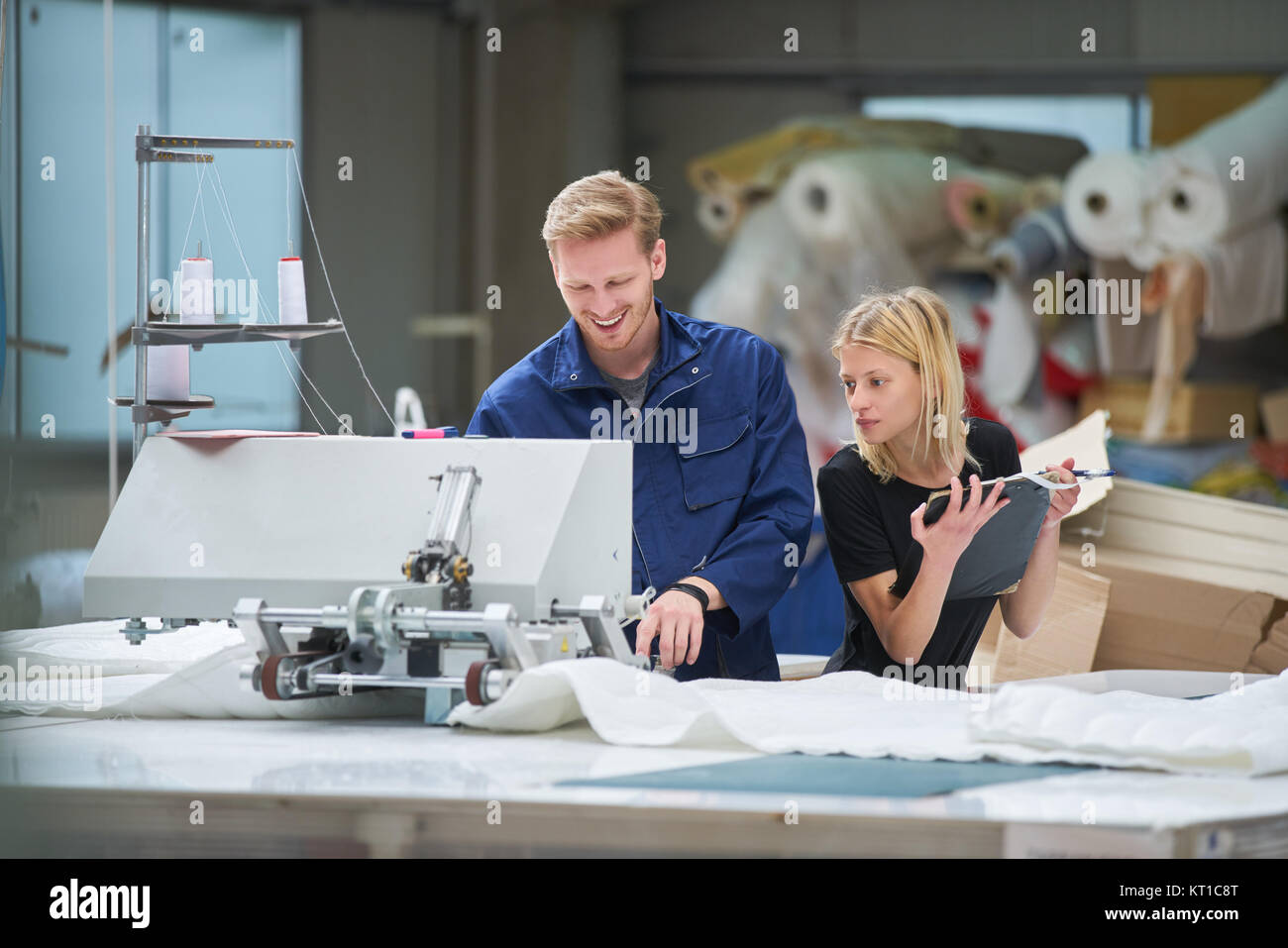 Seamstress is new assigned to a machine in a textile factory, the foreman explains something Stock Photo