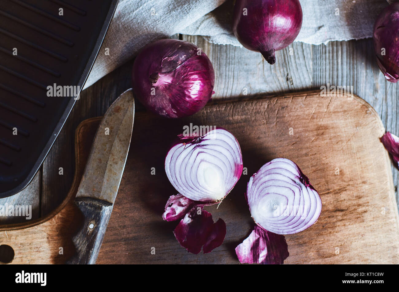Cut in half red onion on a chopping board Stock Photo - Alamy
