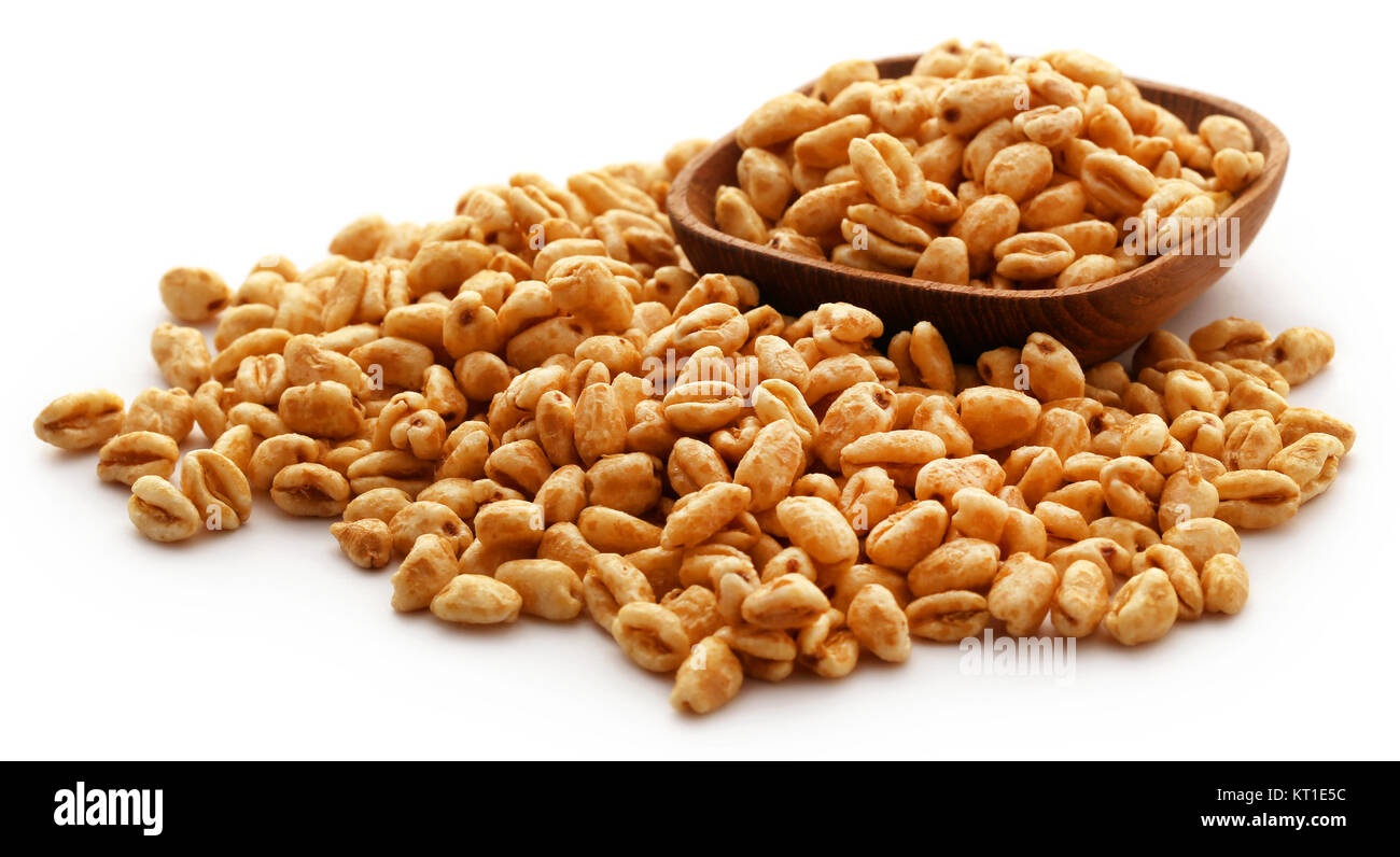 Golden puffed wheat in bowl over white background Stock Photo