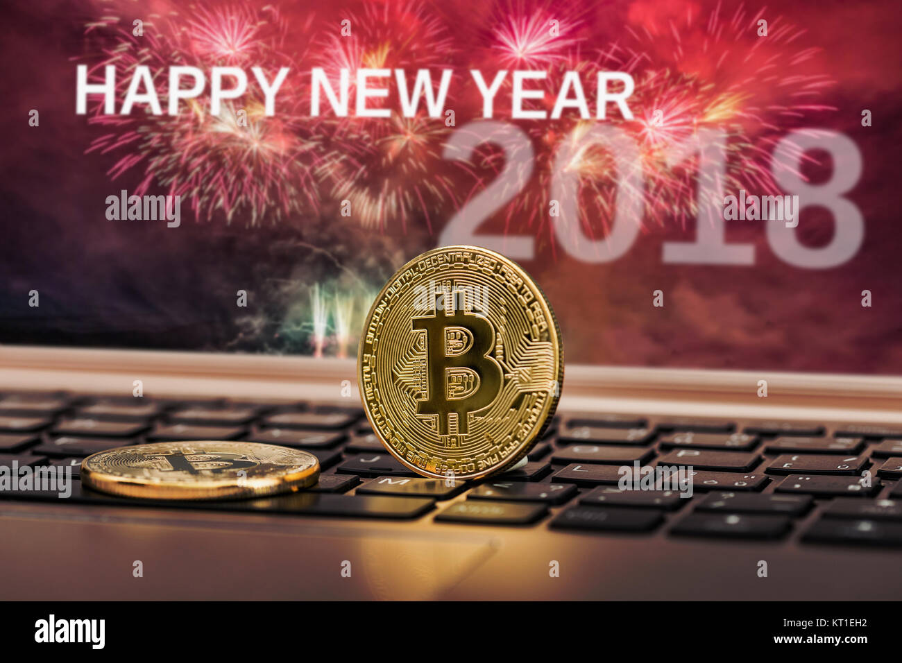 Happy new year 2018 with fireworks background. Celebration New Year 2018, Golden bitcoin coin on the black laptop keyboard. Macro. Stock Photo
