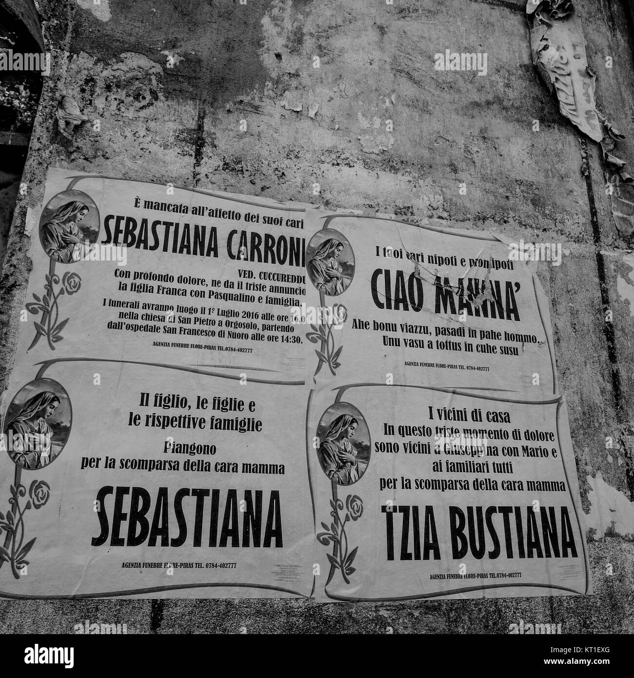 Obituaries glued on a wall in Olbia center, Sardinia, Italy Stock Photo