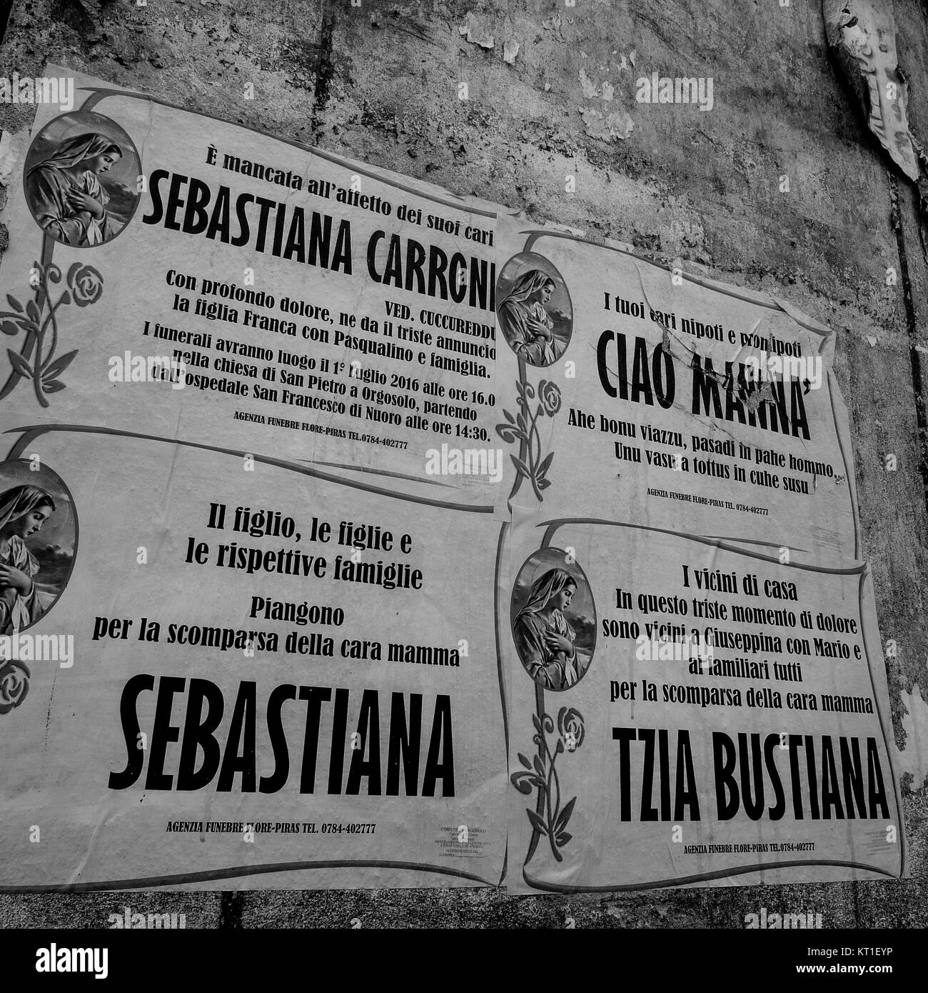 Obituaries glued on a wall in Olbia center, Sardinia, Italy Stock Photo