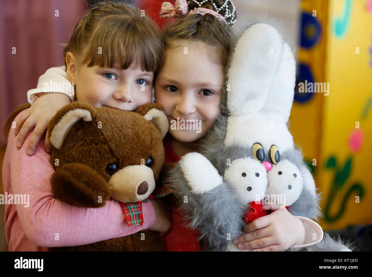 Belarus, the city of Gomel, May 04, 2016. Kindergarten Volotovskaya.Two beautiful girls with soft toys smile, children of girlfriends in kindergarten. Stock Photo