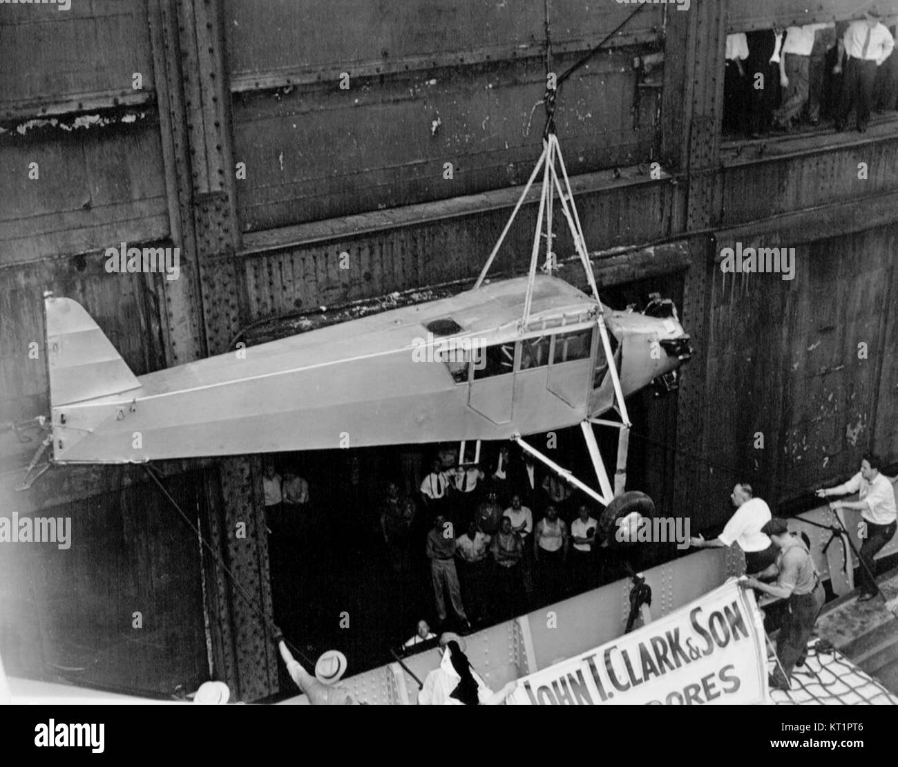 This photograph shows Douglas Corriganâ€™s plane being transported by ship back to the United States in 1938. The event follows his controversial transatlantic flight. Stock Photo