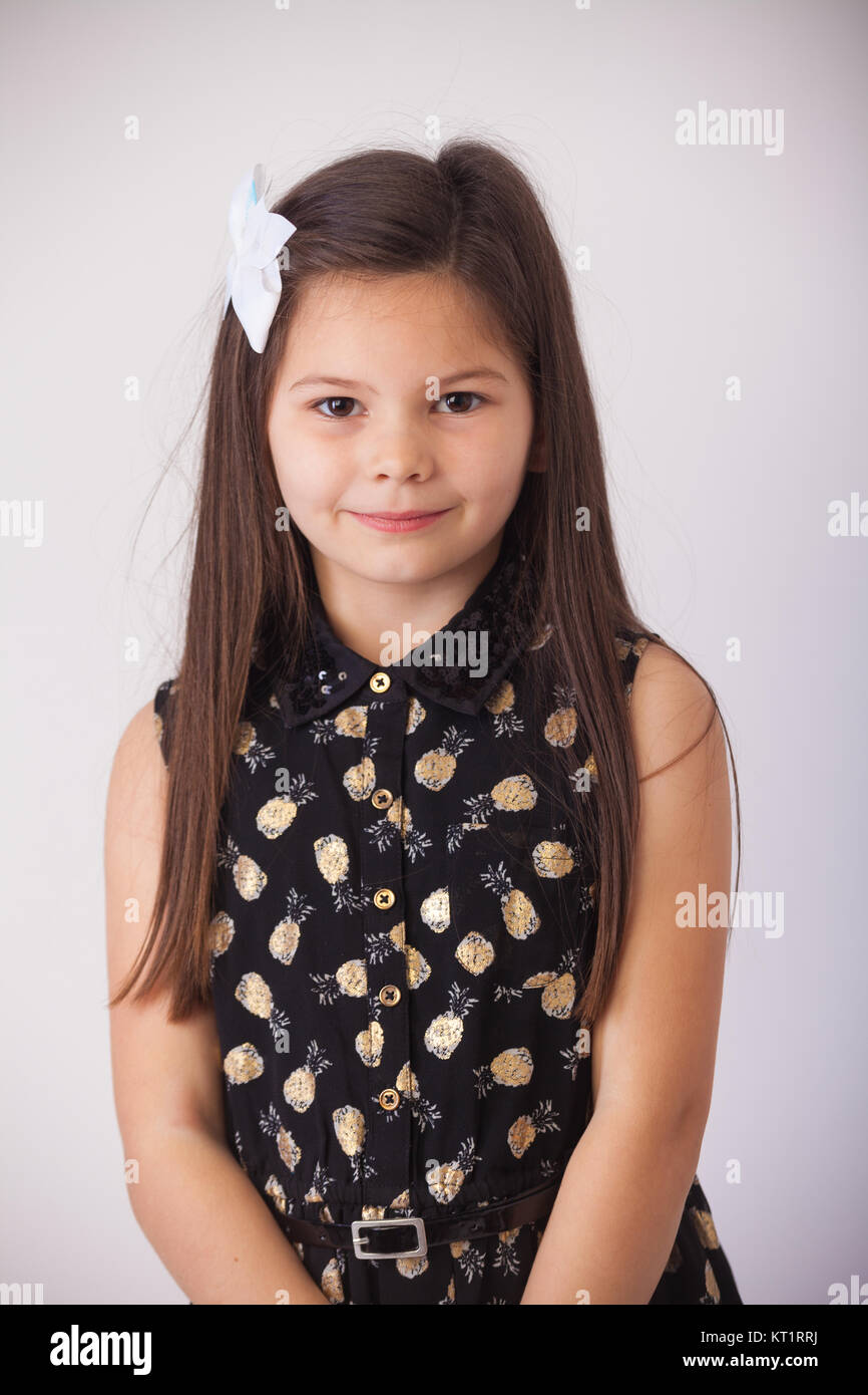 Portrait of a 7 year old girl looking towards camera in a studio. Stock Photo