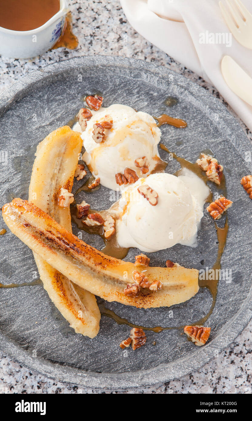 Gegrillte Banane mit Vanille Eiscreme, Karamellsauce und Nuessen Stock ...