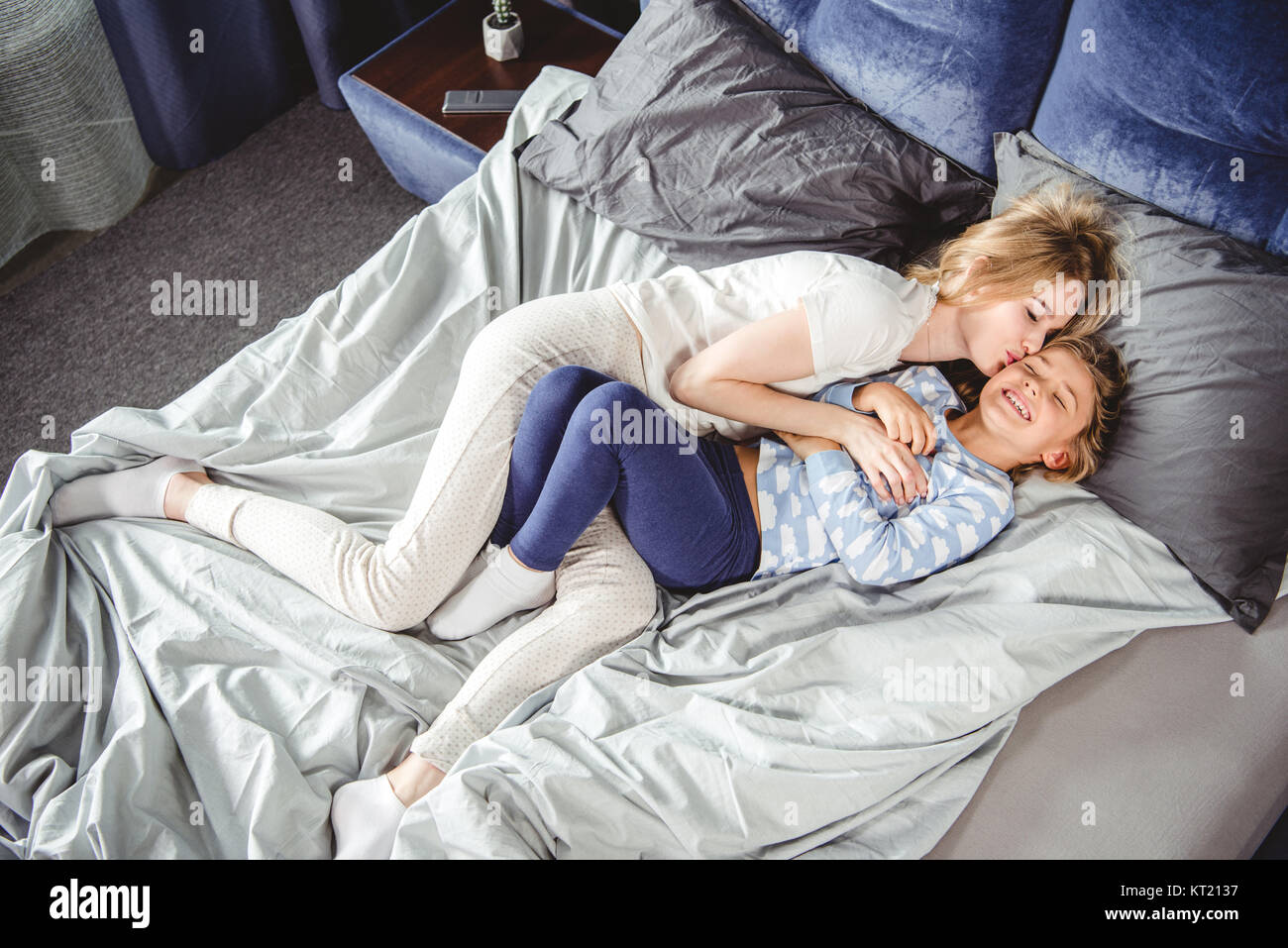 Happy mother and daughter in bed Stock Photo
