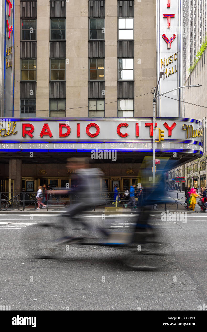 A tricycle taxi drives past the Radio City Music Hall building in Manhattan, New York, USA Stock Photo