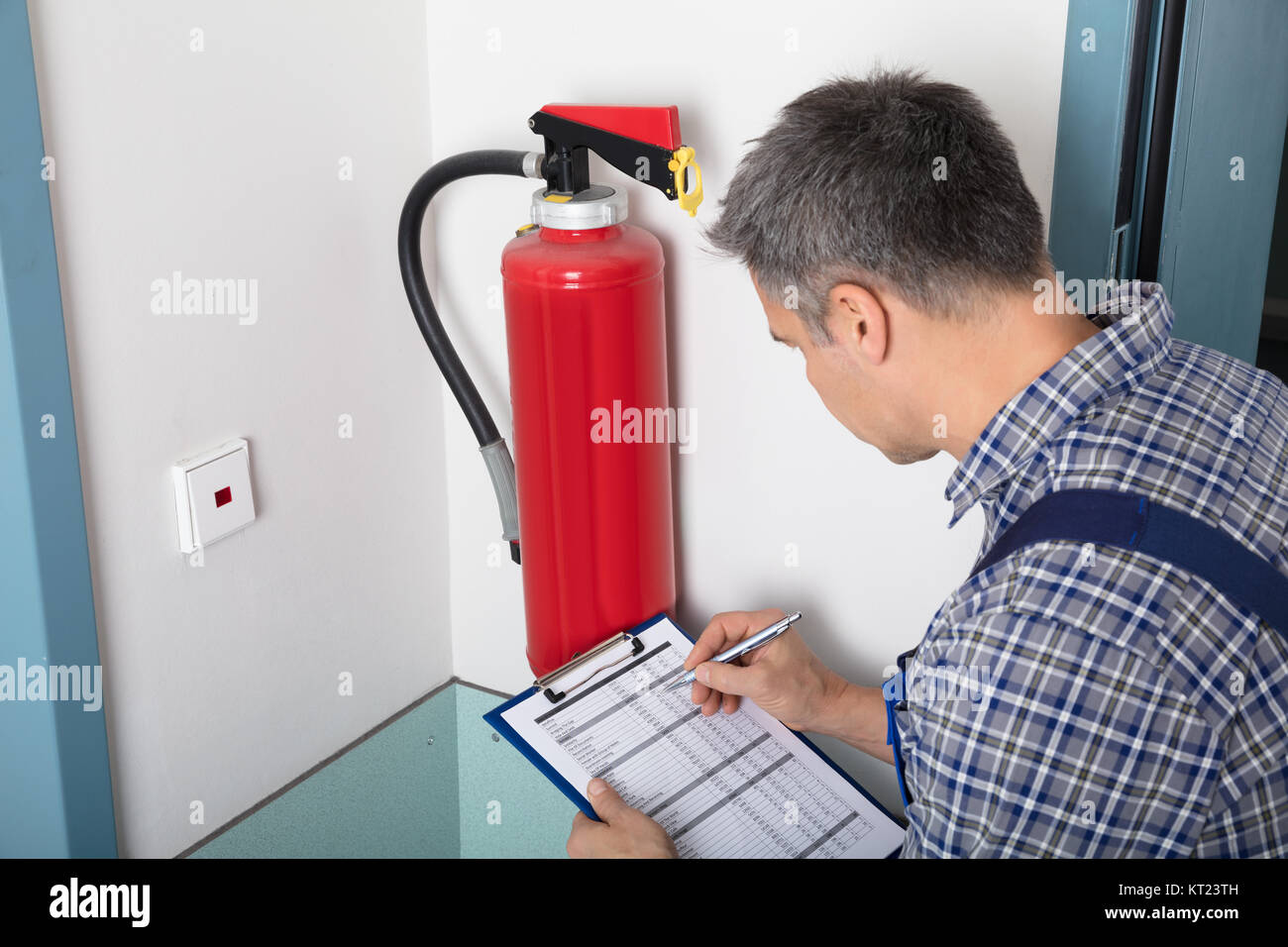 Professional Checking A Fire Extinguisher Stock Photo Alamy