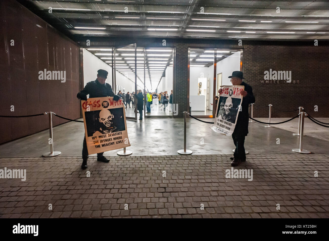 Simon Elmer & Ian Bone stand holding Class War posters at the entrance to the White Cube gallery which is showing Gilbert & George's 'Banners'.2 Stock Photo