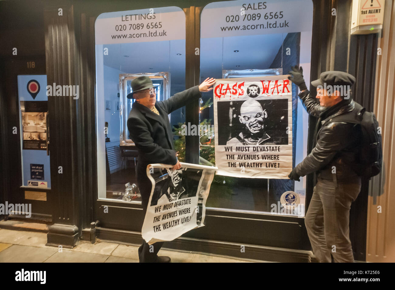Ian Bone and Simon Elmer display the Class War poster 'We must devastate the avenues where the wealthly live' on an estate agent's window in Bermondsey St. Stock Photo