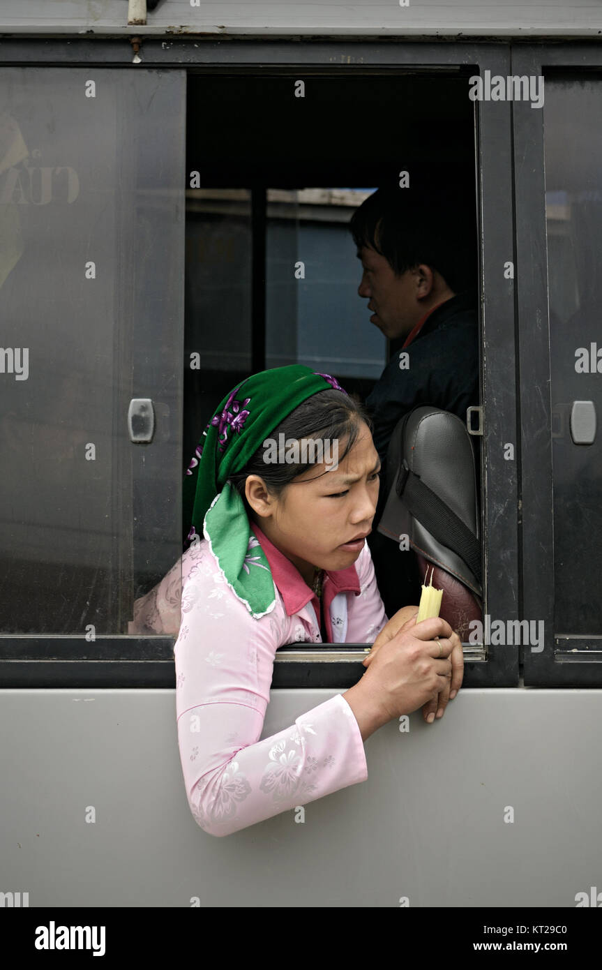 Young woman eating at the window of a bus in Meo Vac market, Ha Giang Province, north Vietnam Stock Photo