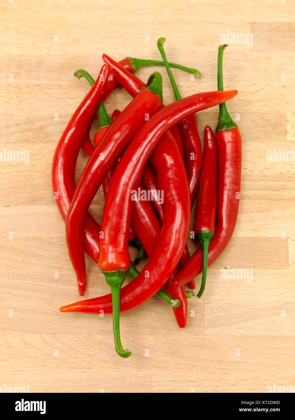 Red chilli peppers on a wooden bench Stock Photo - Alamy