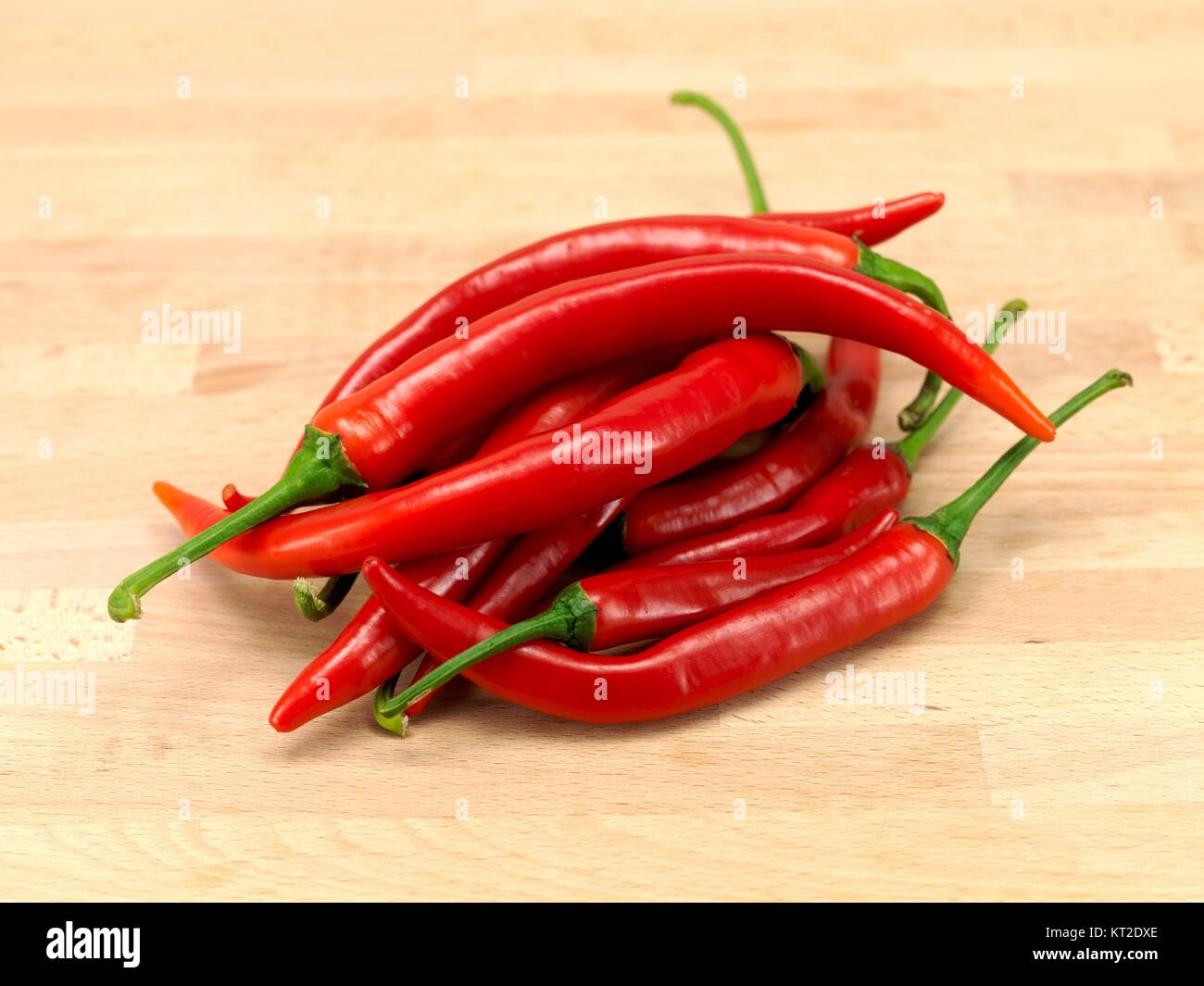 Red chilli peppers on a wooden bench Stock Photo - Alamy