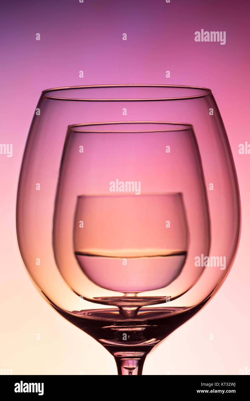 Three empty wineglass for red wine on diffusion lit background in abstract   composition with reflection, advertizing shot for restaurant, winemaking Stock Photo