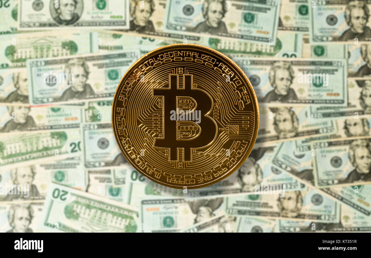 Bitcoin on top of US dollar bills or notes on table Stock Photo