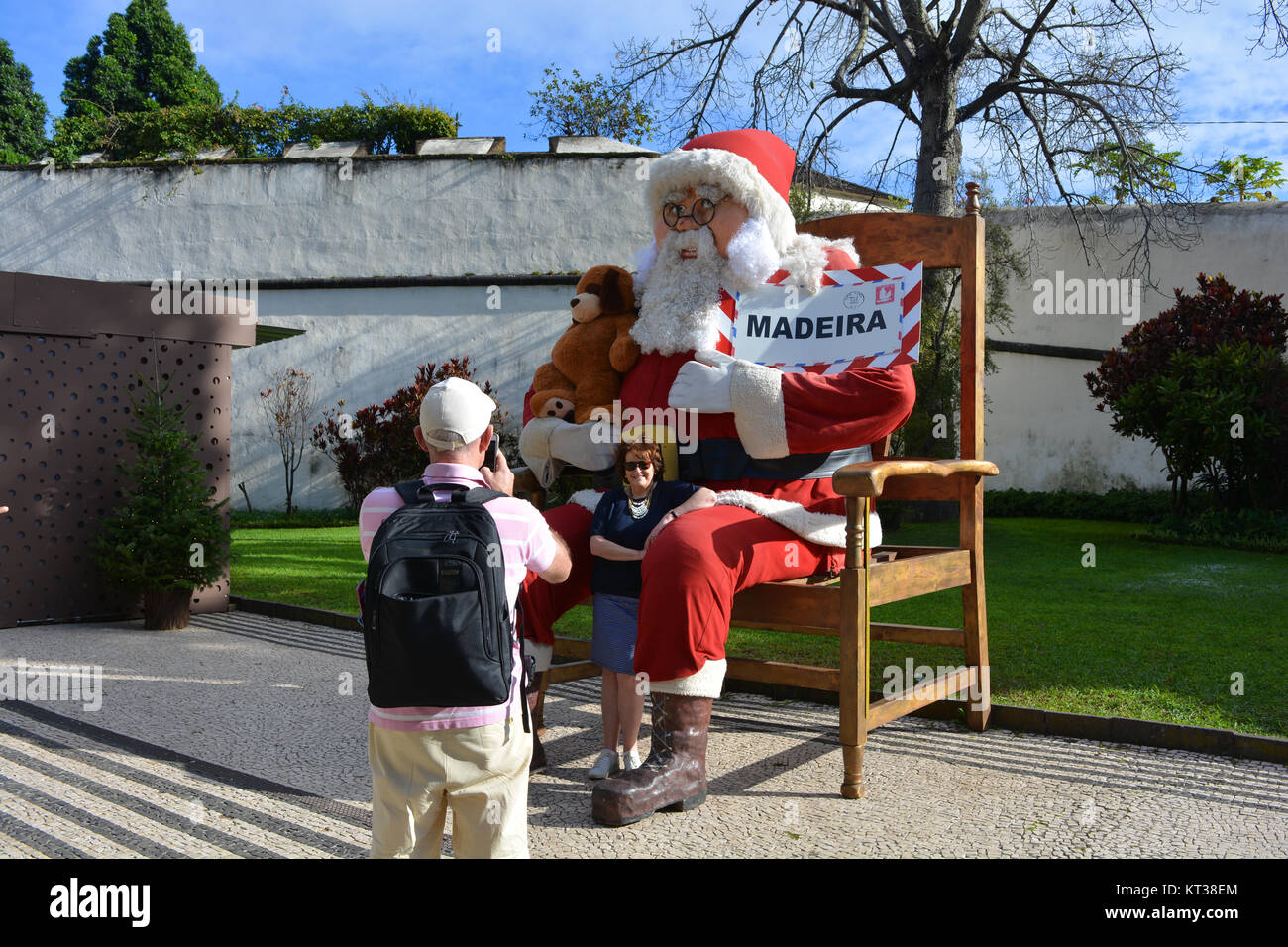 Tourist couple on holiday at Christmas time, taking a photo with Santa on a smartphone, Avenida Arriaga, Funchal, Madeira, Portugal Stock Photo