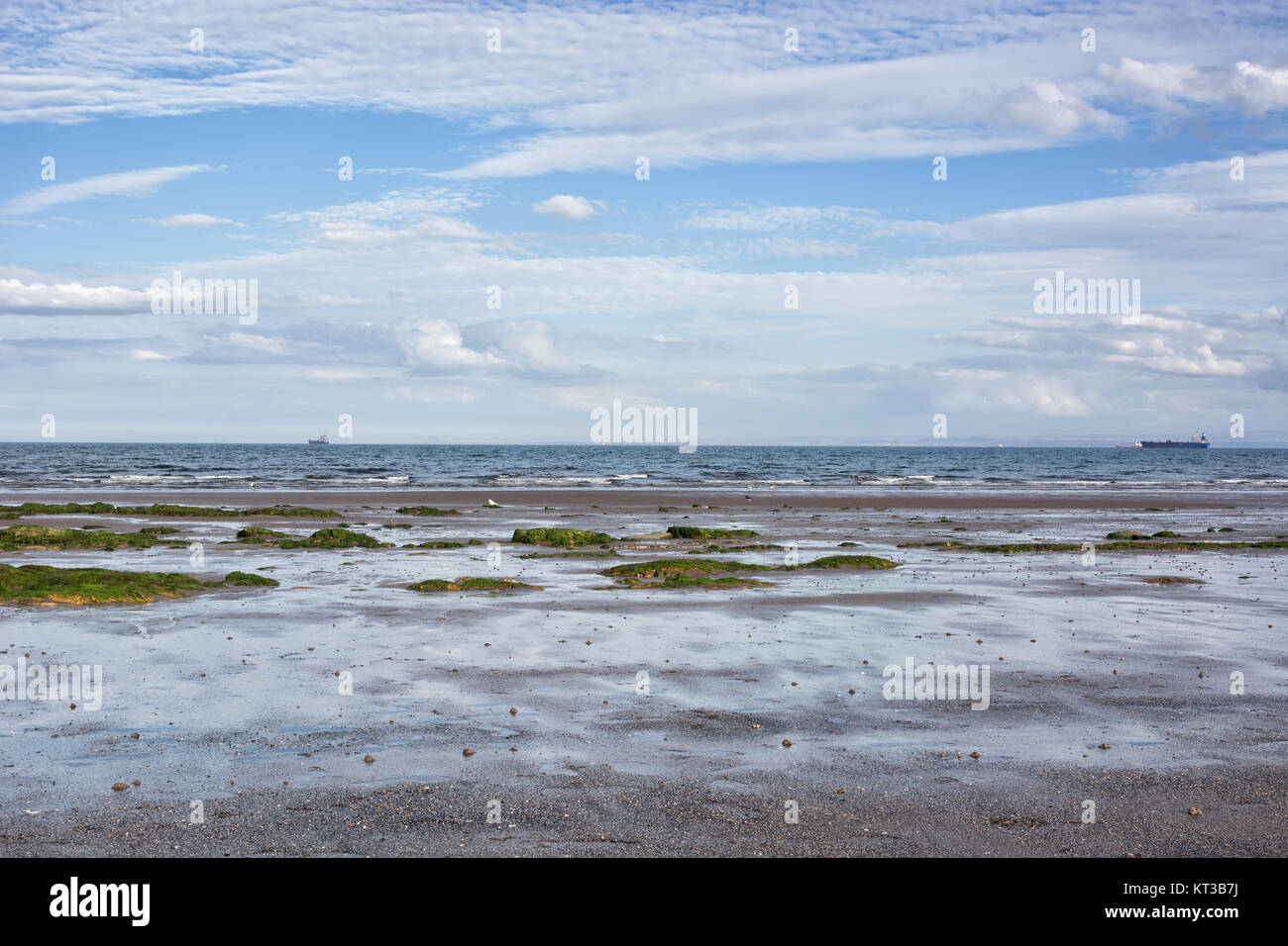 Coastal landscape in Scotland, UK, the town of Kirkcaldy. Low tide, ships on the horizon. Stock Photo