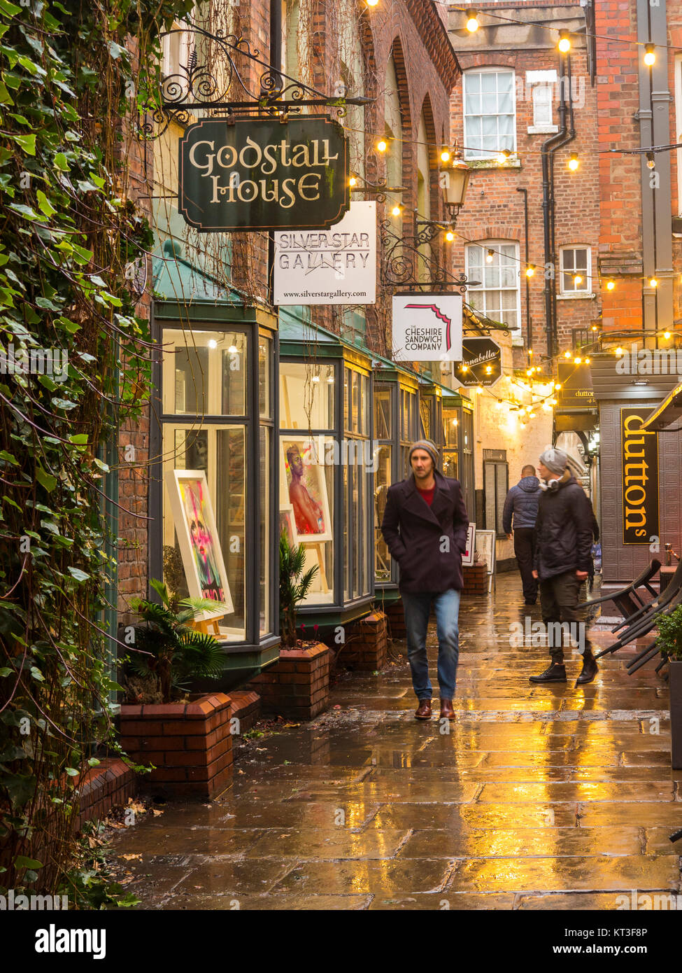 View along the wet pavements of the medieval godstall lane that links the city centre with the cathedral in the roman city of Chester Cheshire England Stock Photo