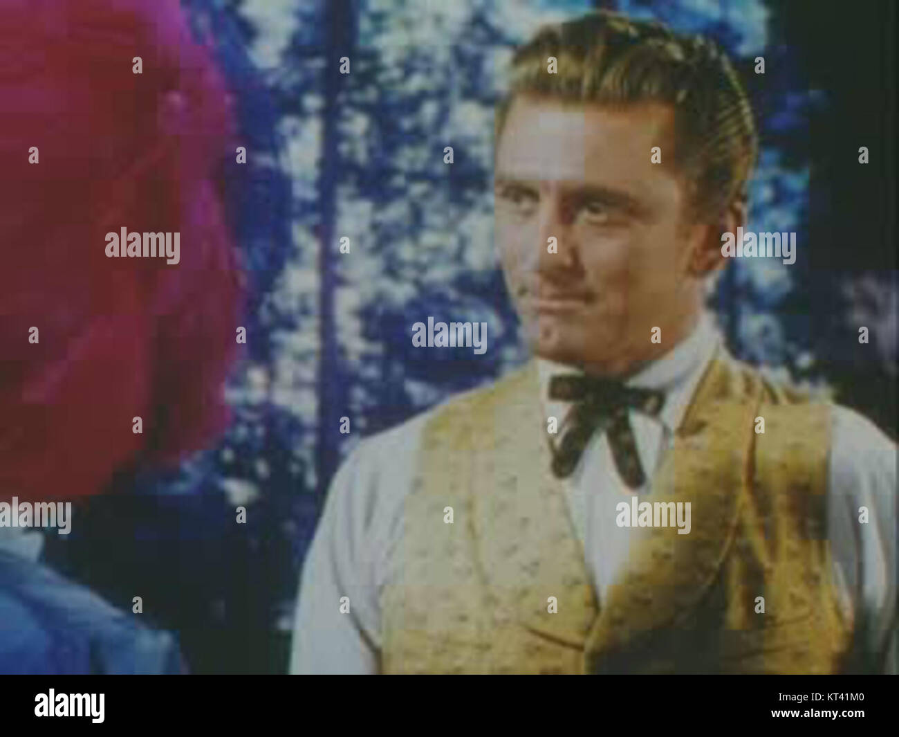 Kirk Douglas is photographed alongside large trees, possibly taken in a forest or natural setting. Known for his iconic roles in cinema, this image highlights his connection to nature. Stock Photo