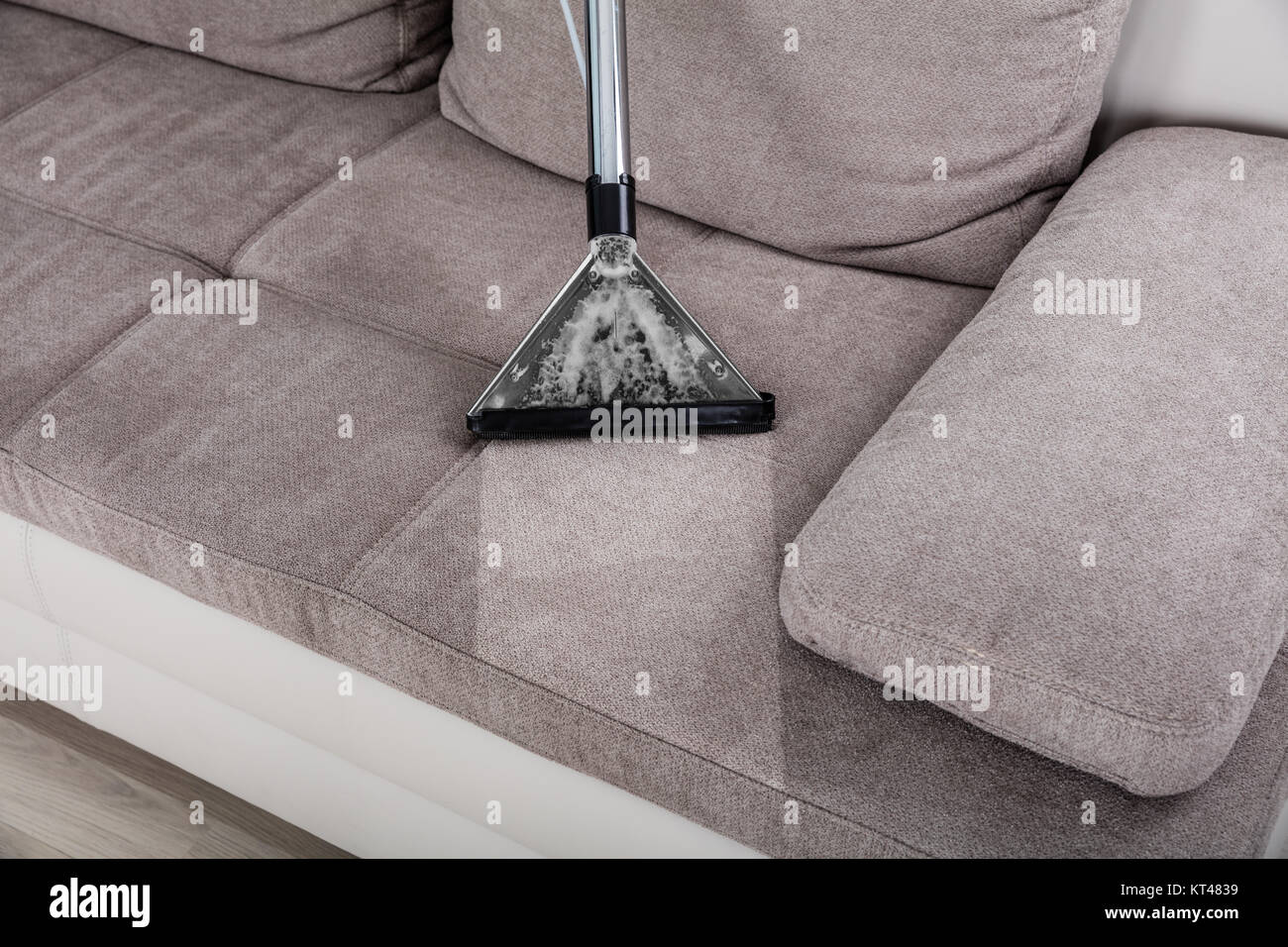 Woman Cleaning Sofa With Vacuum Cleaner Stock Photo Alamy
