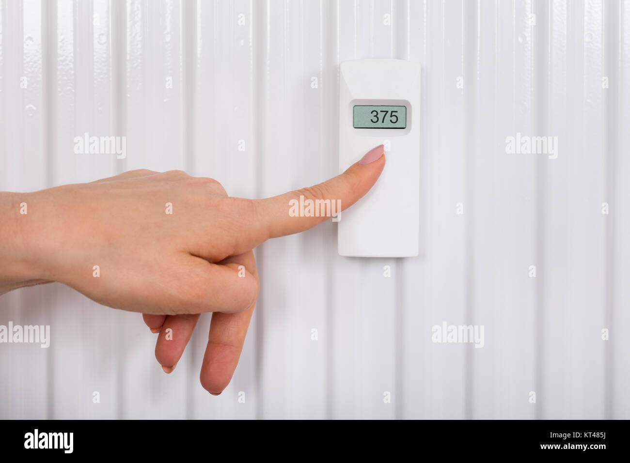Person Adjusting Temperature With Digital Thermostat Stock Photo