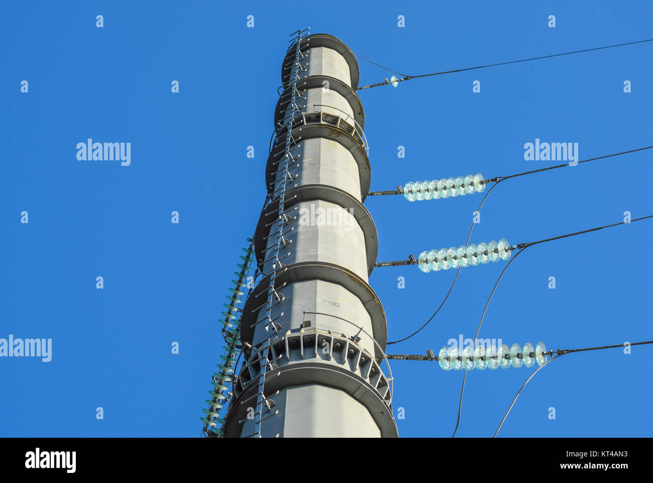 Supports high-voltage power lines against the blue sky Stock Photo - Alamy