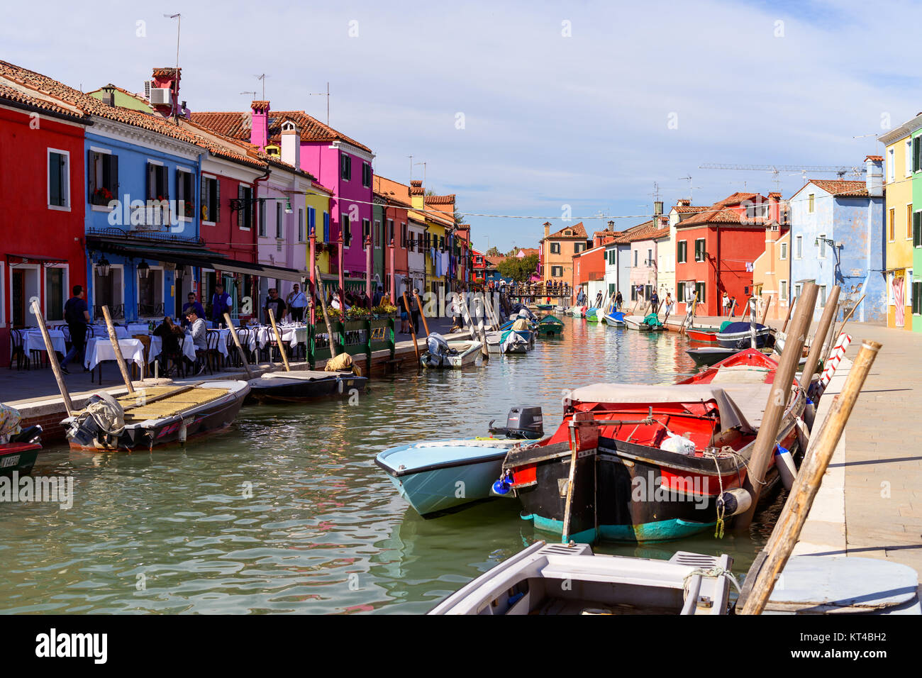 Tourists and colorful houses along the canal on the Venetian island of Burano, Venice lagoon, Burano, Italy Stock Photo