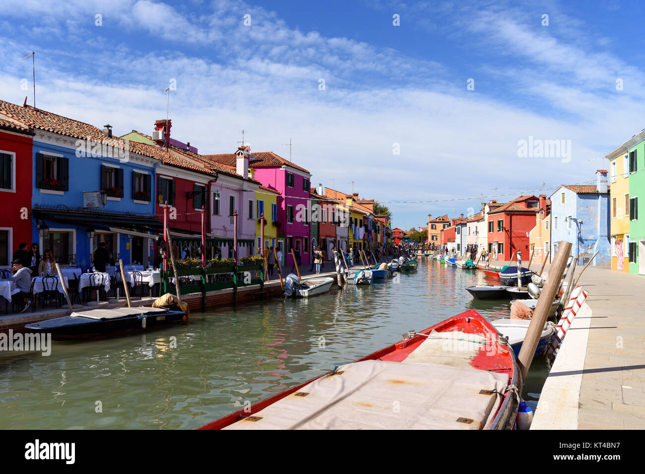 Tourists and multi-colored houses along the canal on Burano island, Venice lagoon, Veneto, Ialy Stock Photo