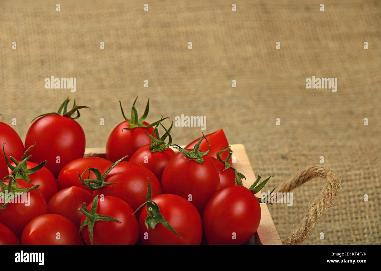 Red cherry tomatoes in wooden box on canvas Stock Photo - Alamy