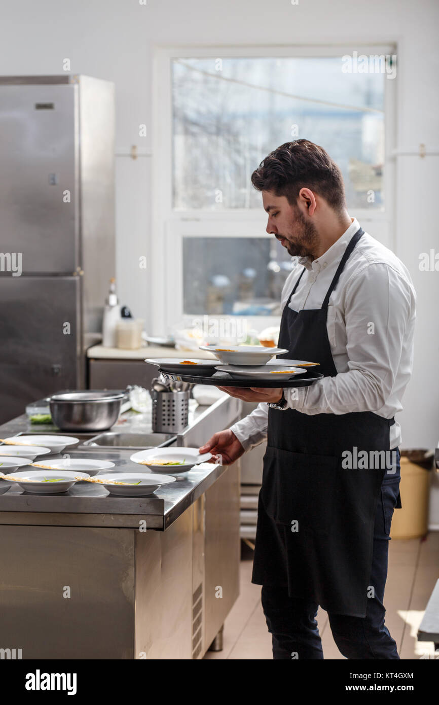 Young waiter wearing apron Stock Photo Alamy
