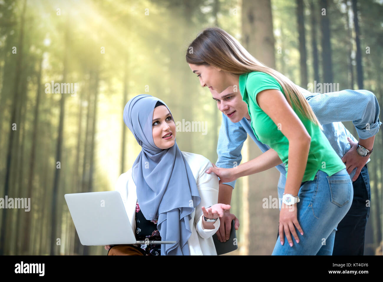 diverse college students using laptop and talking, learning exchanging