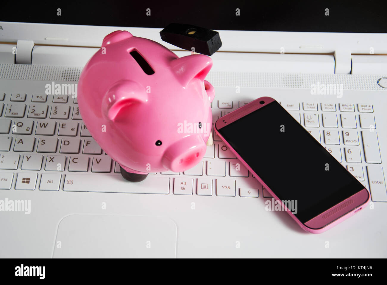 Sparschwein mit Handy auf einer Tastatur Stock Photo