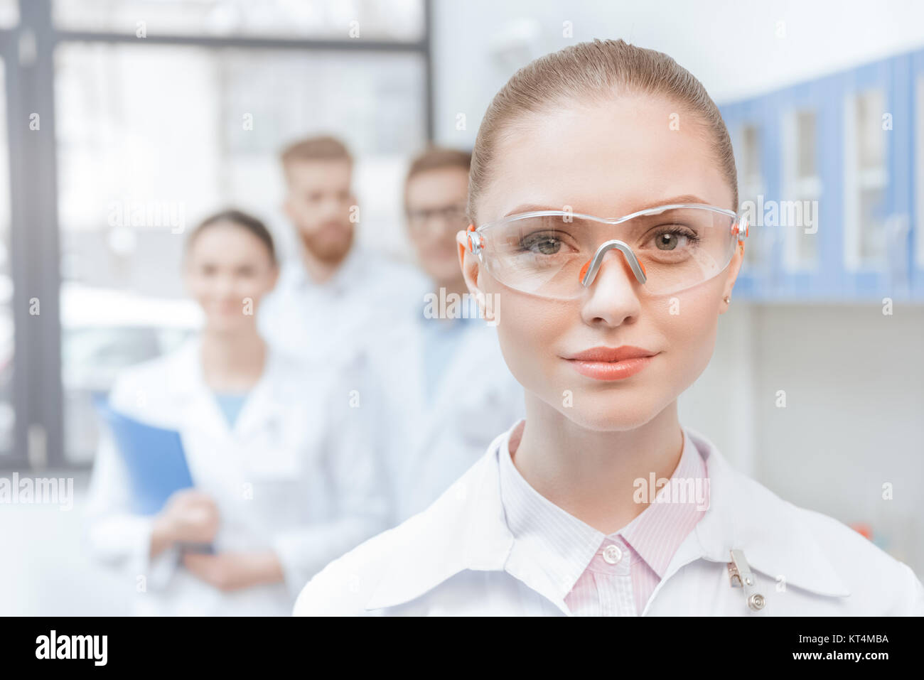 Closeup portrait of young woman scientist in lab coat and protective