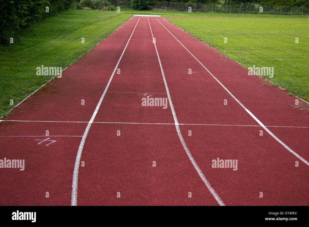 sports field with red running track and white stripes in styria in summer Stock Photo