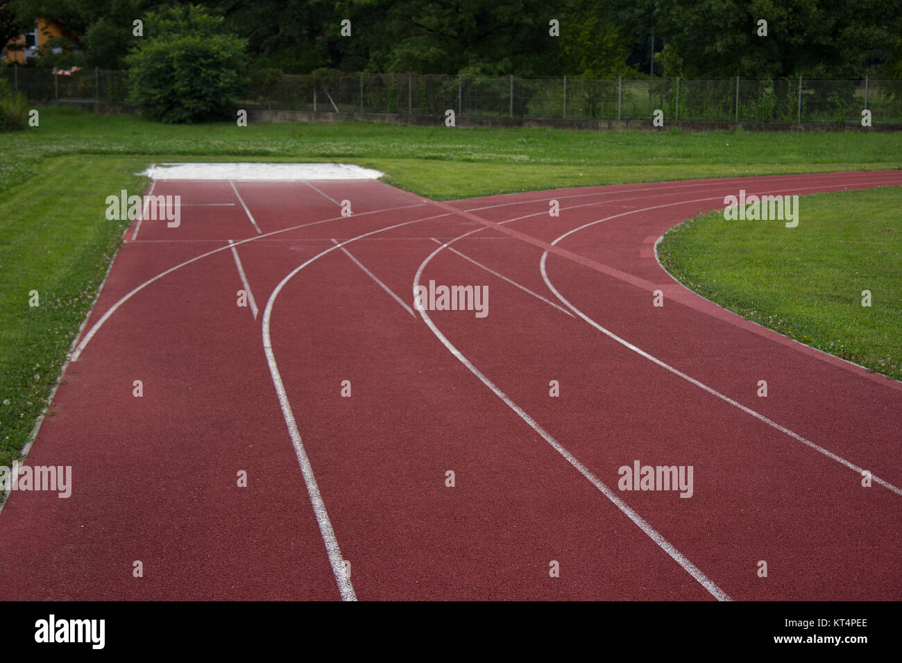 sports field with red running track and white stripes in styria in summer Stock Photo